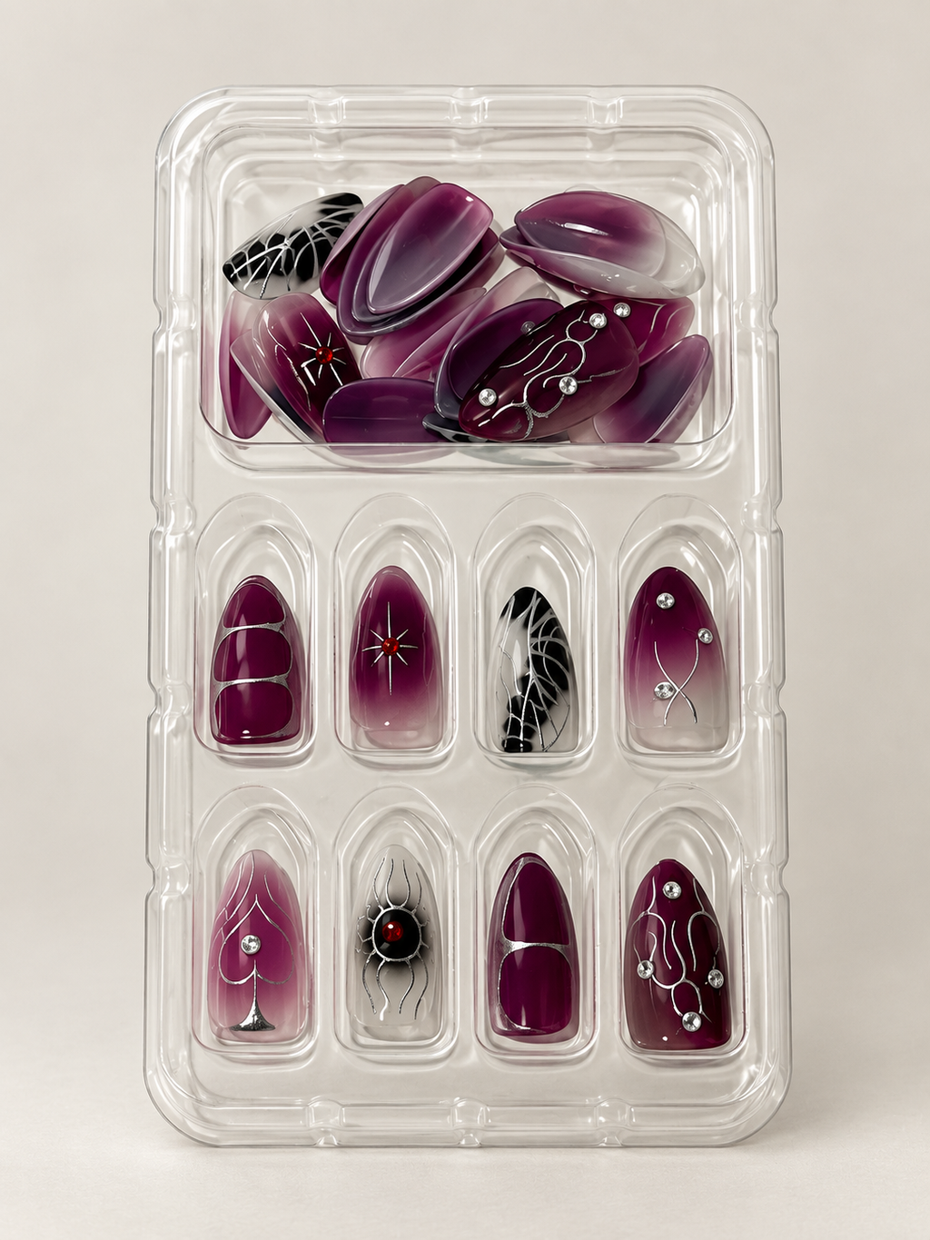 Dark plum ombre press on nails with silver spider and web details in tray