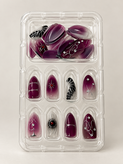 Dark plum ombre press on nails with silver spider and web details in tray