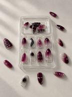 Dark plum Halloween press on nails in tray with loose nails around
