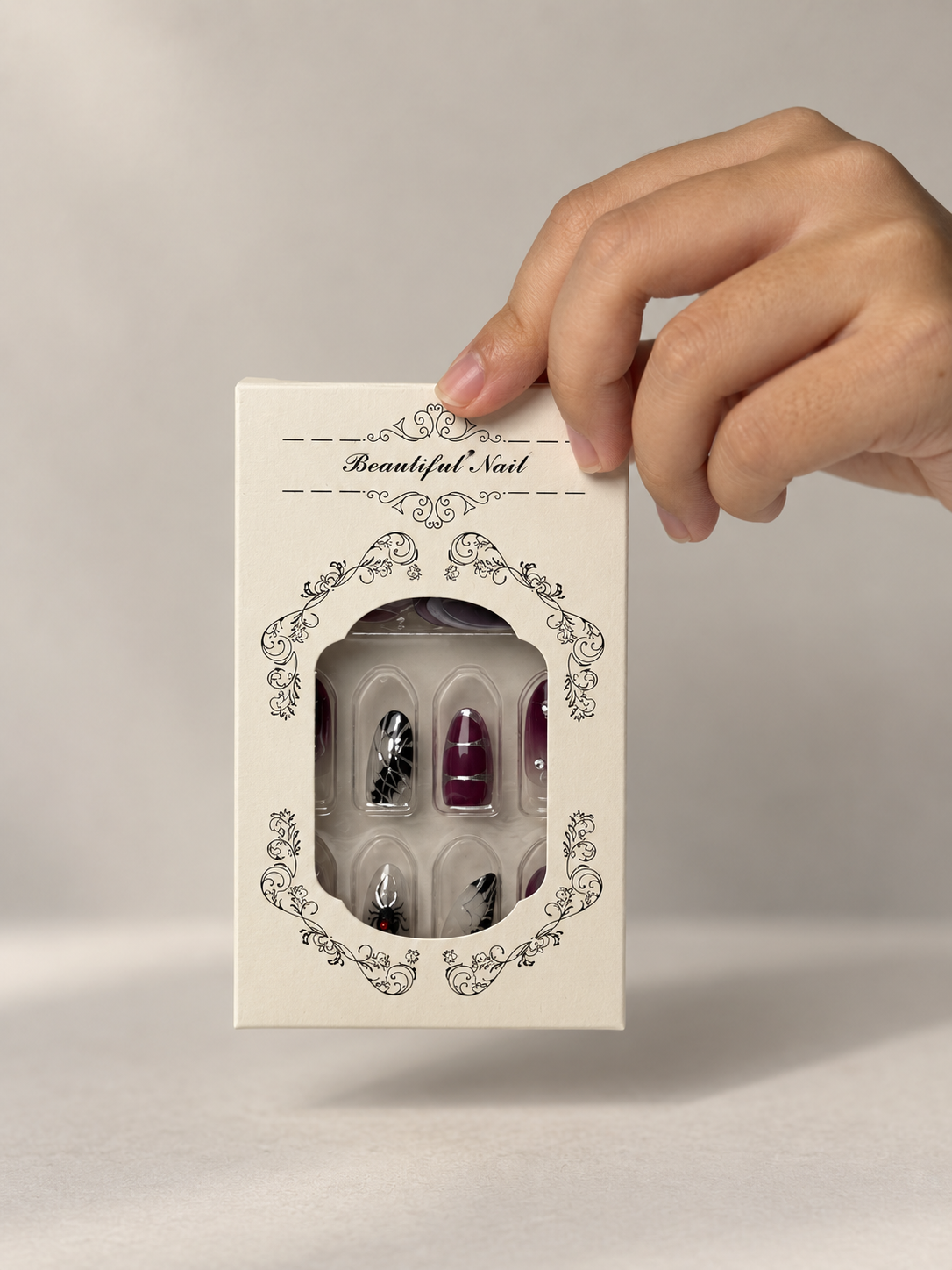 Dark plum press on nails packaging box held in hand