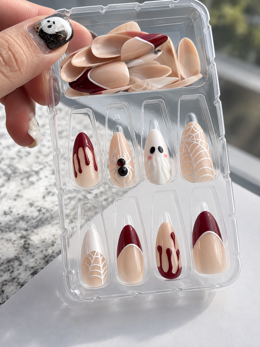 Red ghost spiderweb drip press on nails in tray held in hand